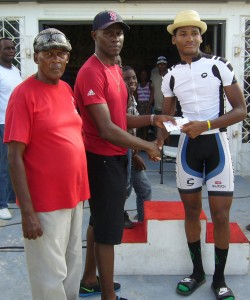 Michael Anthony  receives his cash prize from sponsor Wilbert Benjamin as organiser Randolph Roberts savours the moment.