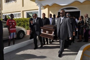 Family Members and those of the sports fraternity bearing the remains of Aubrey Henry from the Church following the Thanksgiving Service yesterday.     