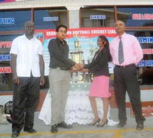 Shavane Sookall of Metro presents one of the trophies to Russell Jadbeer of GSCL Inc. in the presence of Samuel Kingston (left) and Bernard Ramsaroop. 