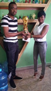 Proprietor of ZSK Wholesale Beverage Depot and Restaurant, Kelly Quow (right) hands over one of the top trophies to NEE Director, Shareef Major yesterday in Linden.