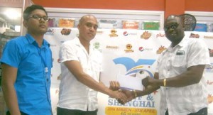  Mr. Low Koan presents Aubrey Major (right) with the sponsorship package in the presence of Pream Sudargan.