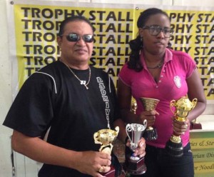 GBA President Gokarn Ramdhani (left) and Trophy Stall Sales representative Ms. Petronella John display the trophies up for grabs.