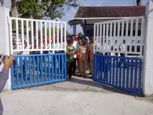 Mrs. Bhaskarran cuts the ribbon that hold the newly installed gate in the presence of Commander Hicken and other police officers and ranks. 