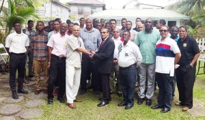 GOA President, K.A Juman Yassin hands over the GABF plaque to BBA President, Greg Todd with GABF President, Nigel Hinds (centre) observing the moment with the players of both teams and other officials. 