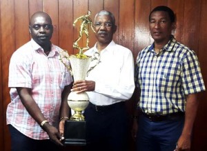 Leader of the Opposition and Presidential for the APNU+AFC coalition David Granger, hands over his ‘Fair Play’ trophy to Aubrey ‘Shanghai’ Major (left) and Kashif Muhammad yesterday. 