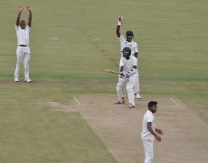 Leon Johnson and keeper Anthony Bramble appeal for caught behind as Chadwick Walton misses a cut at Devendra Bishoo who captured 4-62 for the Jaguars.