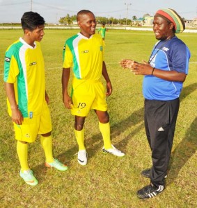 Delano Mentore (left) and Jermaine Junior chat with Assistant Head Coach Wayne Dover. 