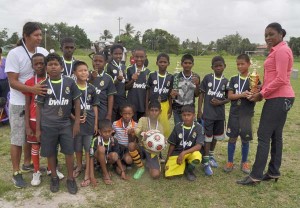  MCYS Director of Youth Ms. Gillian Frank (right) presents the winning trophy to Herstelling Raiders Captain Shoran James in the presence of teammates. 