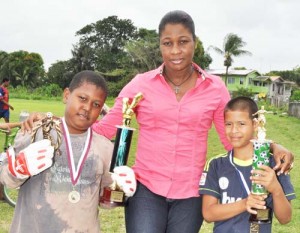 MCYS Director of Youth Ms. Gillian Frank is flanked by Best Goalkeeper & MVP Christopher Adams (left) and Highest Goal Scorer Shoran James.   