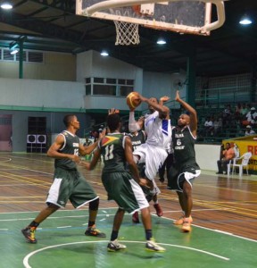 DEFENCE! Bermuda’s Sullivan Phillips (with ball) is smothered by Guyanese defenders in the paint Thursday night at the Cliff Anderson Sports Hall.