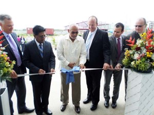  President Donald Ramotar cutting the ceremonial ribbon for the new Qualfon Providence location. With him are (from left) Kirk Laughlin, Founder of Nearshore Americas, Minister of Finance Ashni Singh, Qualfon CEO Mike Marrow, Founder and Chairman of Qualfon Alfonso Gonzales, and Qualfon Vice President Scott Warner