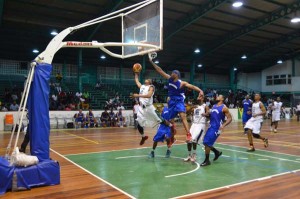 Guyana’s Shelroy Thomas goes up and under against three Bermudian defenders Wednesday night at the Cliff Anderson Sports Hall.