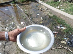 Mr. Fernandes showing the quality of water that is pouring out the water taps.