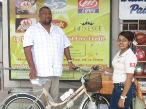 A representative of A. Ally & Sons hands over a bicycle to Hilbert Foster. 