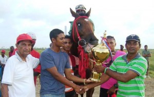 Connections of Sent From Above receives the winning trophy in the feature G3 and lower event. Jockey Paul Delph is perched on top of the animal.