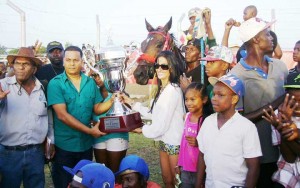 Banks DIH Limited Supervisor Nandram Basdeo along with employees Ashanie Williams and Michelle Dougin presents the Beautiful Banks DIH Trophy to representatives of the Elcock stable for CP Got Even telling victory. 