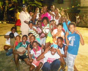 Second in Charge of Police ‘A’ Division, Superintendent, Dion Moore the prizes to the children that participated in a football match in the Central Georgetown Police Youth Group Appreciation Day of Sports at Leopold Street.