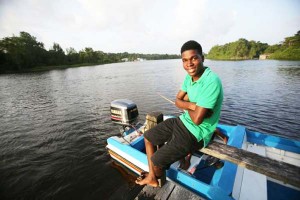 Patrick Daly poses on a dock outside a health clinic along the Pomeroon River in the interior of Guyana March 15. He volunteers at the clinic as a way of giving back after a U.S. doctor and Mercy Sister paid for his surgery to remove a large tumor. (CNS photo/Bob Roller)