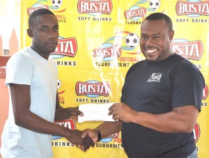  Sparta Boss representative Devon Millington (left) receives the first prize money from Petra Organisation Co-Director Troy Mendonca yesterday, at the Guinness Bar on Durban Street.