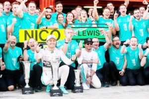 Mercedes’ Nico Rosberg and Lewis Hamilton celebrate after finishing first and second respectively with their team.  (Reuters/Albert Gea)