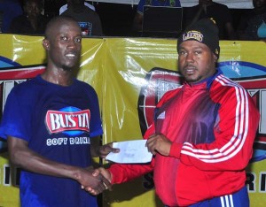 Tournament MVP Sheldon Shepherd collects his monetary award from Petra Organisation Troy Mendonca on Tuesday night.