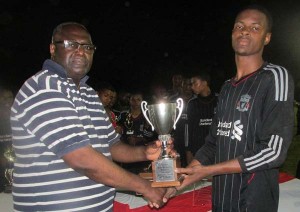 The President of Edward ‘Screw’ Richmond Foundation hands over MVP Trophy to Shane Lucky.