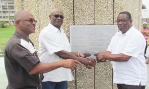 Mr. Bacchus (right) handing over the cheque at the Independence Arch