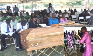 (From left) Calvin Robert’s two sons, his two sisters, his brother and his mother mourn his loss yesterday as his bat which was buried with him is on his Coffin.  (Inset)  An emotional Celina Patricia Johnson hugs her dead son’s photograph at Calvin Roberts’ funeral yesterday.