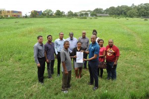 Eccles/Ramsburg NDC Chairman Mr. Saeed Khan and GFF NC Chairman Clinton Urling hold up the signed Lease in the presence of other officials from the two entities at the Providence ground yesterday. 