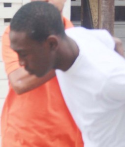 Police escort Orandel Noel after he was remanded to prison.