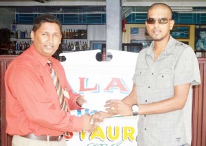 BCB executive Vicky Bharosay receives sponsorship from Jagdeshwar Sarran, owner of Palace Taxi Service and Bar. 