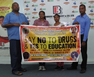 Officials of RHTY&SC and Edward B. Beharry display the banner recently at the sponsor.  