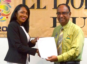 Mrs. Sharda Veeren-Chand (left), Marketing Director of Demerara Distillers Limited hands over the contract to CPL OPCO Team Operations Manager, Omar Khan.