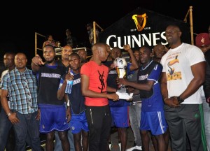 Caribbean Skills Challenge champion Trinidadian Mark Taylor (fourth left) hands over the winning trophy and first prize to Sparta Boss Captain Devon Millington in the presence of teammates, Guinness Brand Manager Lee Baptiste (right) and Tournament Organiser Troy Mendonca (left) on Sunday night.