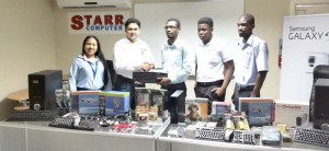 General Manager of STARR Computer Rehman Majeed (2nd from left) hands over one of the many items to Revon Thormon and Mikkel Zephyr of GTI, in the presence of company representatives.