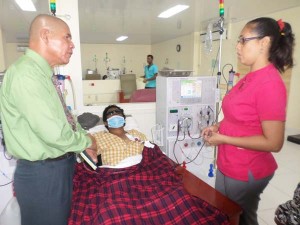 Minister of Public Health, Dr. George Norton, talks with Head Nurse, Olive Sinclair, about Anil Singh’s condition.