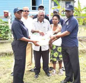 Laurie Greenidge and his wife receive a hamper from members of the Grove/Diamond CPG. 