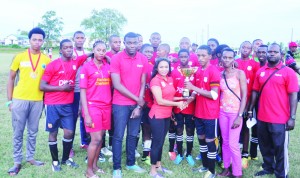 Captain of BHS Derick Taylor collects the Region 6 Trophy from a Digicel Rep while his team and their Head Mistress Tracey Helligar (at Taylor’s right) share the moment