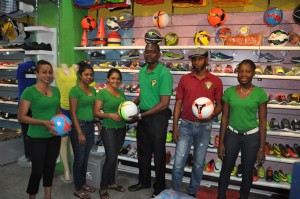 Colours Boutique staffer Shondel Kandar (3rd left) hands over one of the footballs to  Fruta Conquerors Secretary Daniel Thomas in the presence of fellow staffers yesterday.