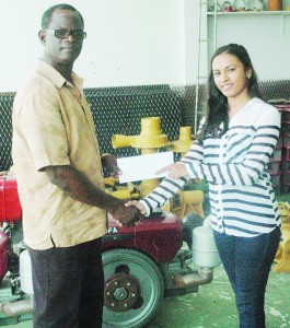 Accountant at K&B Mining, Anisa Husain (right) hands over the sponsorship cheque to Colin Boyce yesterday at their Church Street location.