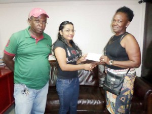 Kaieteur News Advertising Clerk, Nirvanie Mahadeo (centre), hands over  the cheque to Mrs Donna Harcourt in the presence of Mr. Eustace Harcourt.