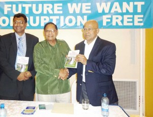 From left, Public Security Minister, Khemraj Ramjattan, and Prime Minister, Moses Nagamootoo  receiving copies of the book from Former Auditor General Anand Goolsarran.