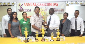 NAMILCO Financial Controller Mr. Fitzroy McLeod hands over the main trophy to RBC President Brian Allen in the presence staff members RBC Secretary Ms. Theresa Pemberton (2rd left) and NAMILCO Assistant to Managing Director Mr Ato Lakeram (right).