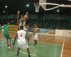 Kwakwani Secondary’s guard, Ronaldo Patoir (with ball) puts the moves on Bishops’ High defence for a right-handed layup in the paint last night at the Cliff Anderson Sports Hall. 