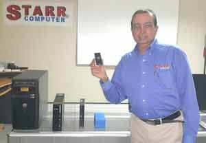 President of STARR Computer, Michael Mohan holds the Intel Computer Stick and compares it to different stages and sizes of desktop computers.