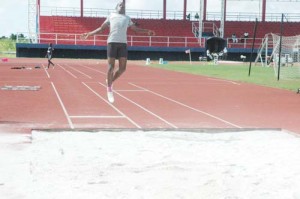 Police’s ‘A’ Division, Yoel Benjamin soars through the air on his way to winning the Men’s Long Jump at the National Track and Field Centre yesterday. 