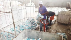 Employees removing damaged toilet paper from the factory.