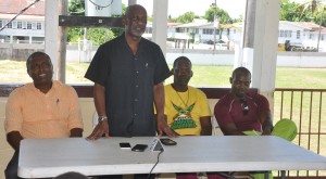 Minister of Housing Keith Scott addresses the gathering at the academy. From left are DCC President Alfred Mentore, Coach Garvin Nedd and Travis Dowlin. 