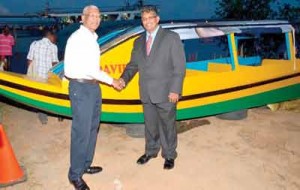 The Head of State being presented with a boat to be used for ferrying children in riverain communities to school, by GAICO CEO, Komal Singh.