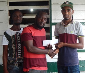 Sherwin Abrams (right) of Dexter’s Jewellery presents the sponsorship package to Eson Pyle, a member of the organising committee. 